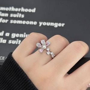 Dettaglio dell'anello a fiore in argento con cristalli rosa e perla indossato sulla mano