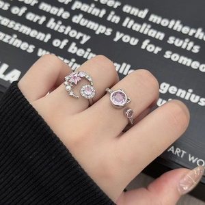 Dettaglio di anelli in argento con zircone rosa a forma di stella e design corona di gatto