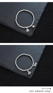 Nahaufnahme von Perlenarmbändern mit gravierten Puzzle- und Geldbeutelanhängern