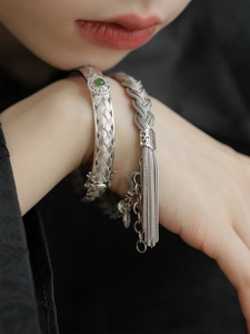 Détail du set de bracelets en argent tissé avec jadéite verte et pompons délicats