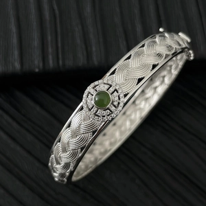 Détail du bracelet tressé en argent avec une pierre de jade verte et des zircons