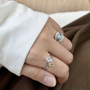 Elegantes Silberring-Set mit Zirkonia in Wassertropfenform und blauem Edelstein am Finger