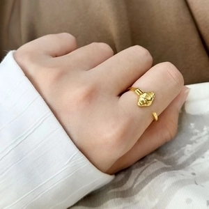 Detail eines goldenen Rings im Croissant-Design mit eleganter strukturierter Metalloberfläche