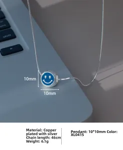 Détail du pendentif smiley en émail bleu sur une chaîne en argent plaqué sur un clavier
