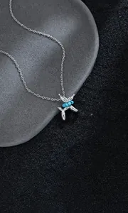Macro shot of silver balloon dog pendant with blue turquoise stone on rock surface