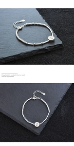 Vue détaillée du bracelet perlé en argent avec pendentif fleur de tulipe émaillée orange