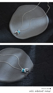Macro detail of silver balloon dog necklace with turquoise beads on stone background