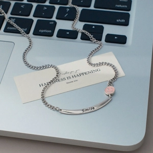 Detail der silbernen Cubankette mit rosa Emaille-Smiley und graviertem Smile-Schriftzug