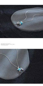 Detail shot of silver balloon dog pendant with blue turquoise beads on cross chain