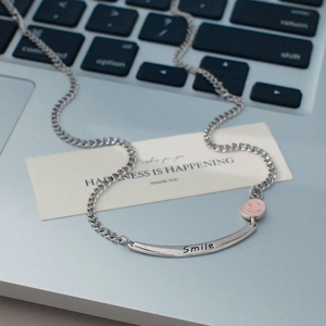 Detailaufnahme der silbernen Kette mit rosa Emaille-Smiley und graviertem Smile-Stab