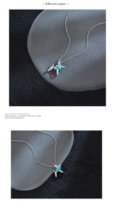 Detailed close-up of a silver balloon dog pendant with blue turquoise beads on a chain