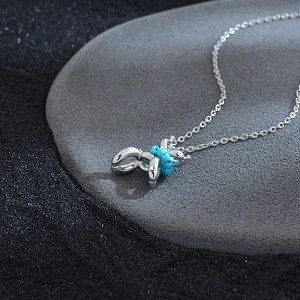 Minimalist silver dog pendant necklace with turquoise beads on a polished cross chain