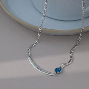 Nahaufnahme der silbernen Smiley-Halskette mit blauem Emaille und Smile-Gravur