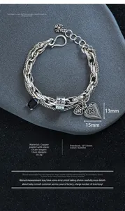 Detail view of vintage multilayer chain bracelet with black zircon and cross charms