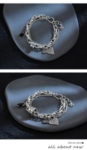 Detailed close-up of retro silver layered bracelet with heart pendant and black zircon