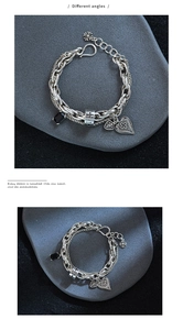 Detailed macro view of vintage silver chain bracelet with black zircon and cross charms