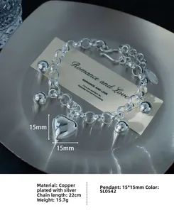 Detailansicht des Herzanhängers und der Metallperlen an einem 22 cm Gliederkettenarmband
