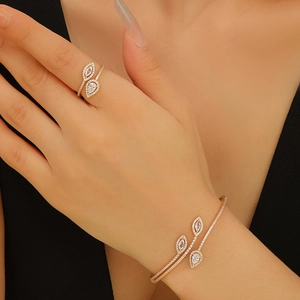 Elegantes Goldschmuck-Set mit doppeltem Zirkonia-Ring im Birnenschliff und passender Manschette