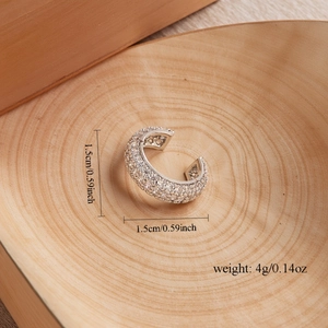 Elegant silver geometric ear cuff with white zircon pavé, 1.5cm diameter on wood background