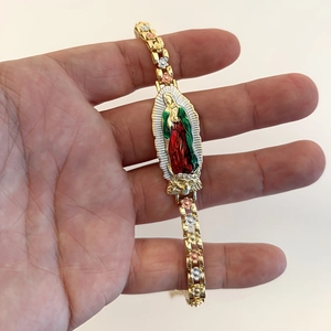 Detailed macro view of tricolor gold bracelet with Virgin of Guadalupe enamel charm