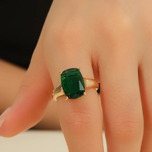 Detailed view of a vintage gold ring with a large rectangular green zircon and textured band