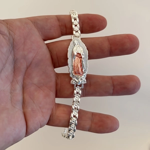 Detail of silver religious bracelet featuring the Virgin of Guadalupe with floral chain