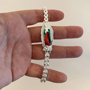 Detail of silver religious bracelet with red and green enamel Virgin of Guadalupe charm