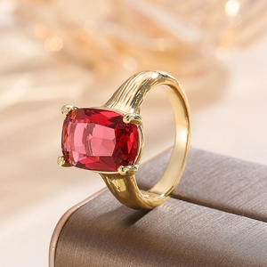 Macro detail of a vintage gold ring with a large rectangular red zircon stone and engraved band