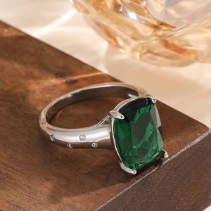 Luxurious cushion-cut emerald green gemstone ring with wide pave-set silver band