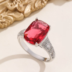 Macro shot of a rectangular red zircon ring with sparkling diamond-encrusted silver band