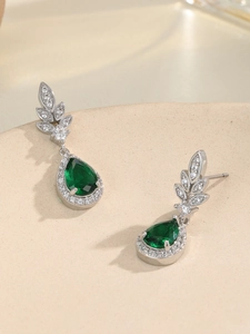 Dettaglio macro di orecchini a goccia in argento con pietre verde smeraldo e zirconi lucidi