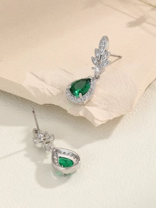 Dettaglio degli orecchini a goccia d'argento con zircone verde e micro-pavé di cristalli