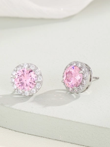 Vista macro di orecchini a lobo halo con zircone rosa rotondo e montatura in argento