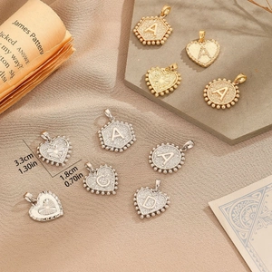 Golden and silver irregular letter charms set on stone tray with vintage background