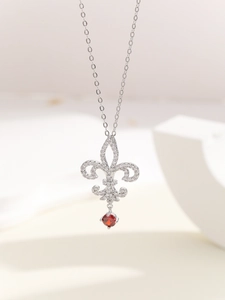 Detalle del collar de plata Flor de Lis con circón blanco y colgante de piedra roja