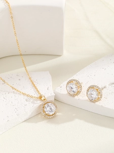 Detail of elegant gold halo jewelry set with round zircon stones on textured stone