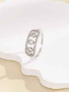 Detail of silver ring with a rectangular frame featuring three sliding round cubic zirconia
