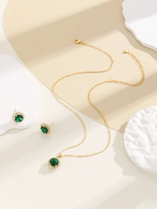 Detailed macro view of sparkling emerald green stone necklace and stud earrings set