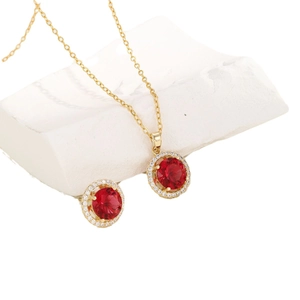 Elegant gold necklace and earrings set with red gemstone and white zircon halo