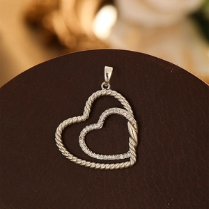 Pendentif double cœur élégant avec texture torsadée et zircons sur socle en bois