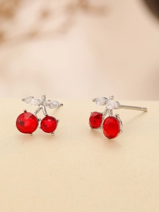 Detailed macro view of cherry stud earrings with red crystals and silver needle posts