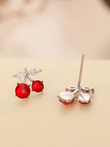 Detailed view of red cherry earrings with faceted crystals and silver leaf settings