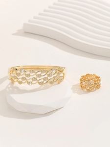 Close-up of gold-plated leaf pattern jewelry set with intricate micro-pave crystals
