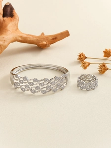 Macro detail of silver plated hollow wavy bangle and ring set with white zircons