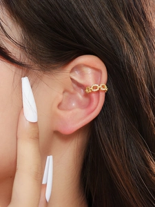 Close-up of gold chain ear cuff with micro-paved zircons worn on a female ear