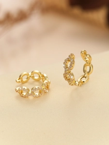 Detailed macro view of 18K gold chain ear cuff with micro-paved pink zircon stones