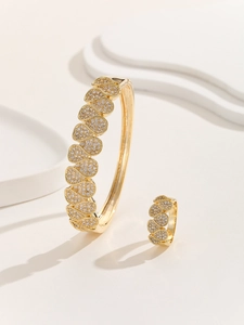Detailed macro shot of gold-plated bangle and ring set with micro-pave cubic zirconia