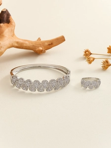 Detailed macro view of silver hollow wave pattern jewelry set with micro-pave zircons