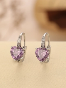 Detailed macro view of heart-shaped purple zircon earrings with small white diamonds