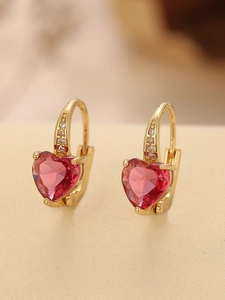 Close-up of heart-shaped ruby earrings with gold plating and micro-pave zircon crystals